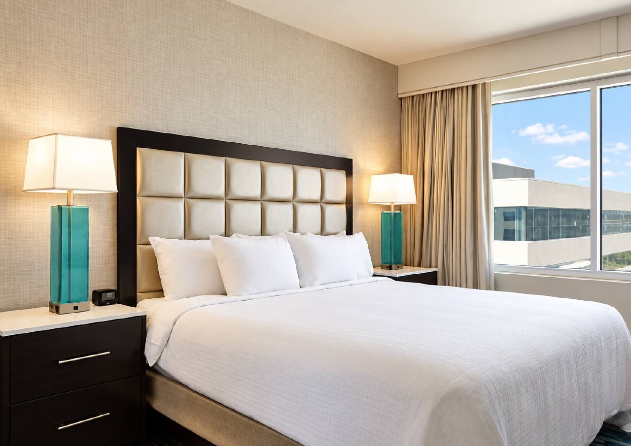 Guest bedroom with upholstered headboard and bedside lighting