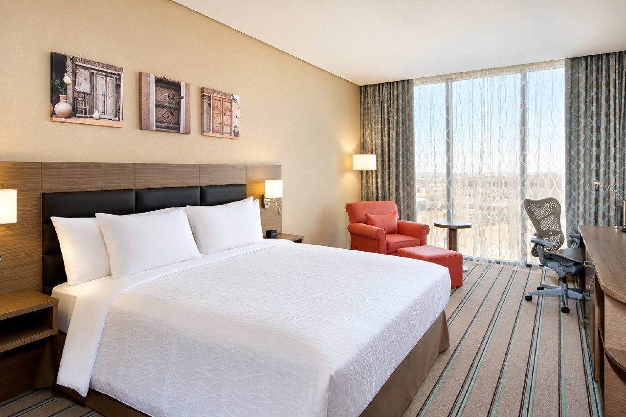 Hilton Garden Inn guest room with king bed, lounge chair and work desk
