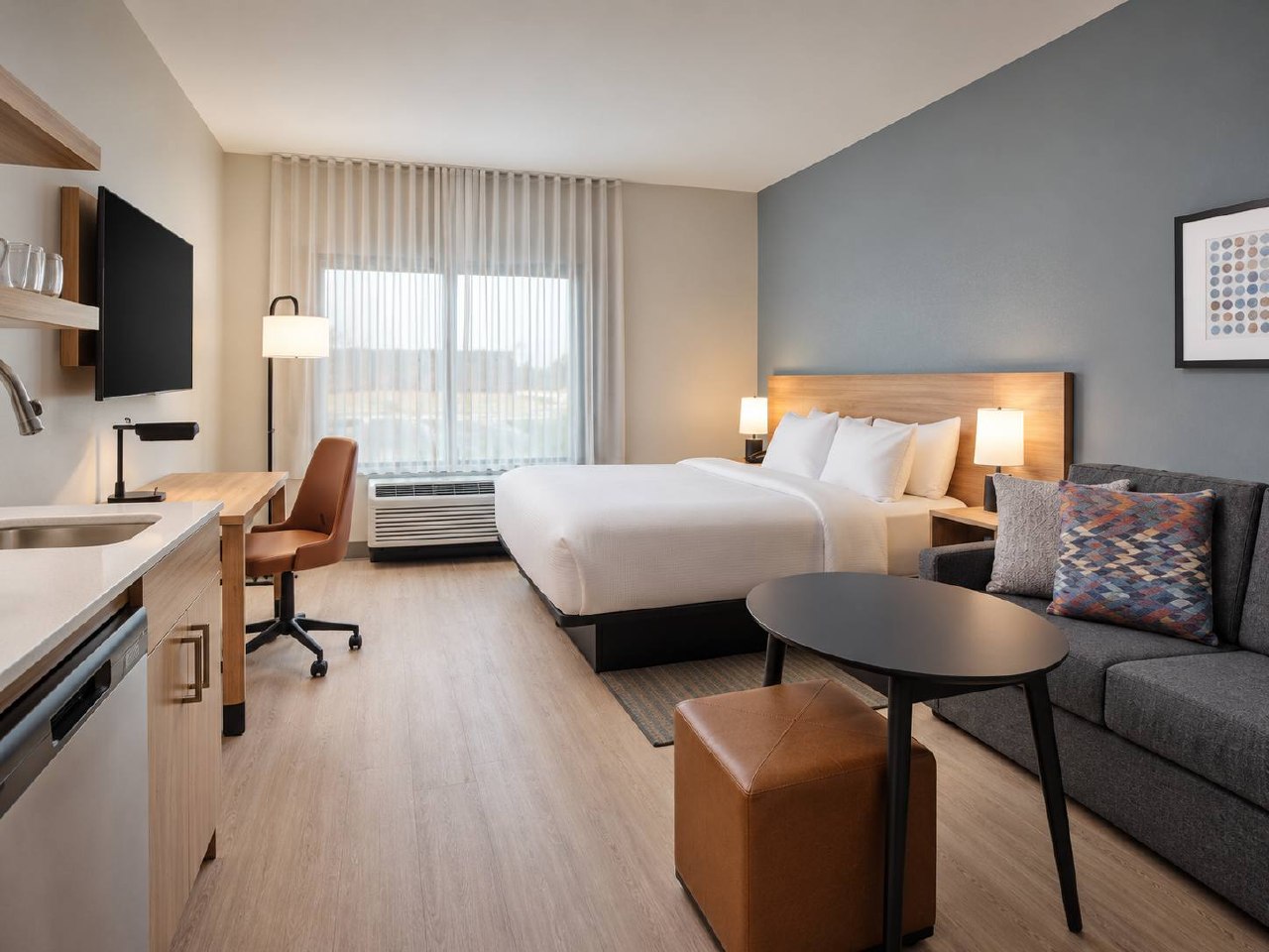 Hyatt Studios guest suite with bed, desk, kitchenette and seating