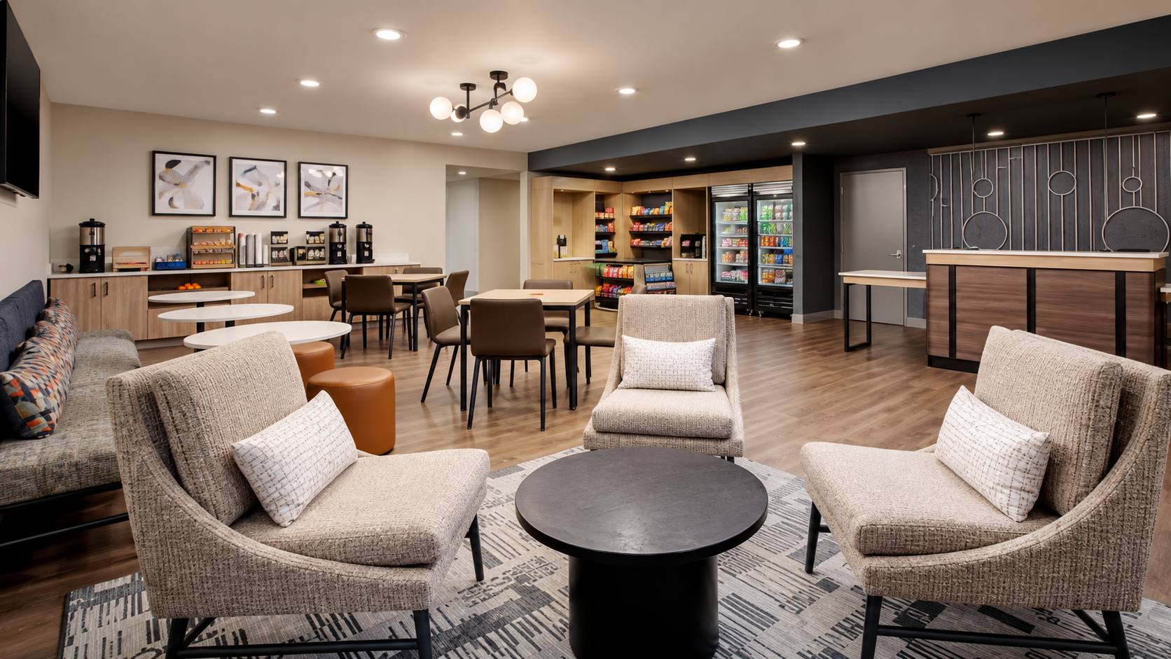 Hyatt Studios shared lounge with seating, dining tables and refreshment counter